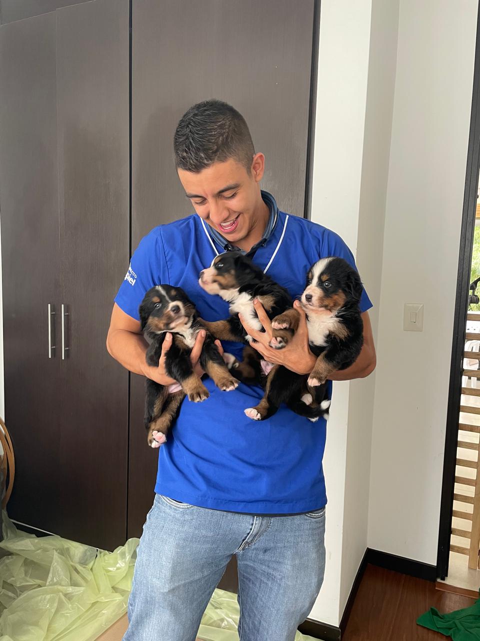 Andrés Gil sosteniendo cachorros durante una atención